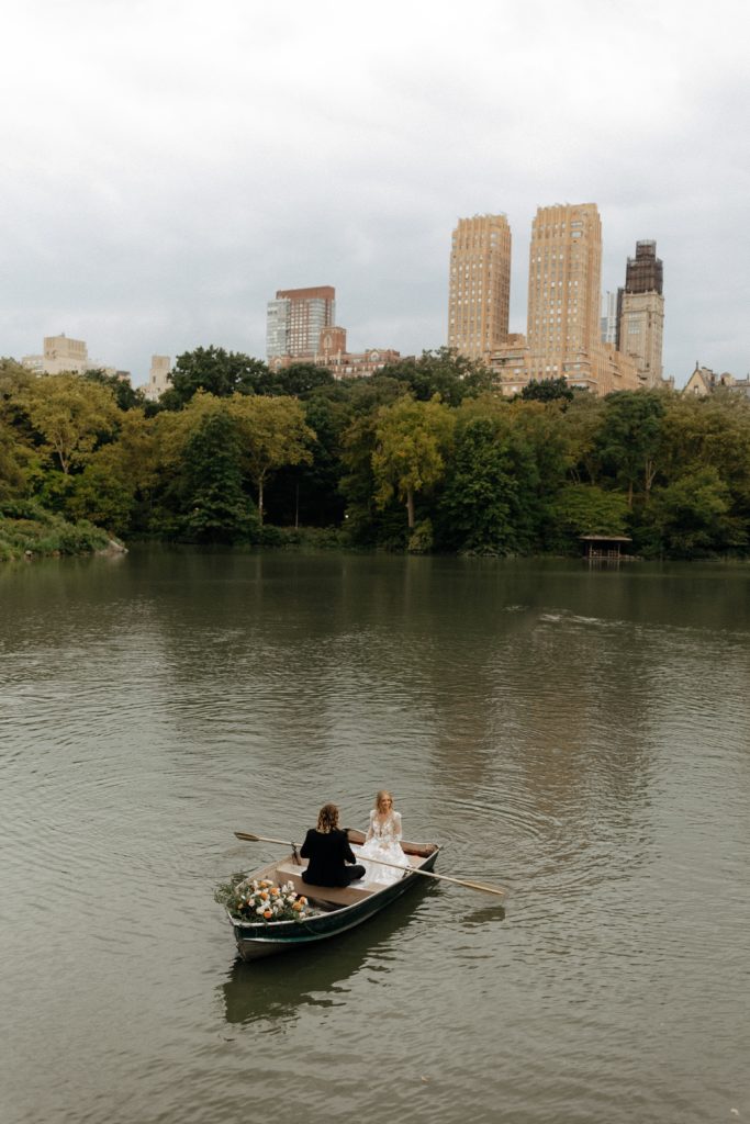 Elope in NYC l Central Park Wedding in the rain with couple rowing in the park pond